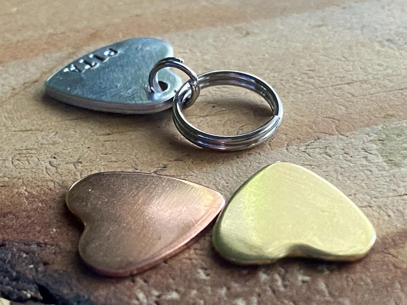 Pu&ograve; includere: Tre etichette di metallo a forma di cuore, una argentata con il nome "Lila" inciso, una di rame e una d'oro.