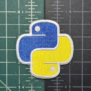 May include: A yellow and blue embroidered Python logo patch. The patch is white outlined and has a textured fabric.