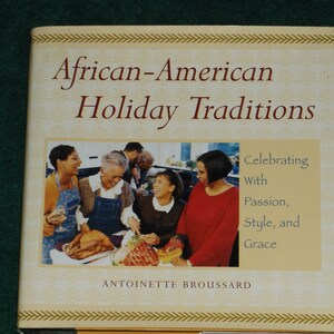 May include: Book cover with a photo of four people smiling and a table with food. The title of the book is "African-American Holiday Traditions: Celebrating With Passion, Style, and Grace." The author's name is Antoinette Broussard.