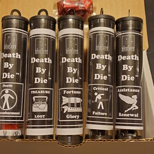 May include: Five black tubes with white labels that read "Death By Die" with different icons and text. The icons include a stick figure, a treasure chest, a hot air balloon, a person with a sword, and a fairy. The text on the labels includes "Death", "Treasure", "Fortune", "Critical", and "Assistance".