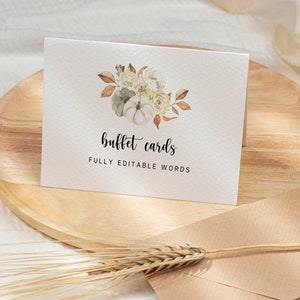 May include: A white folded card featuring a watercolor illustration of pumpkins and flowers in shades of cream, sage green, and rust. The text reads "buffet cards" in a black script font and "FULLY EDITABLE WORDS" in a black sans-serif font.