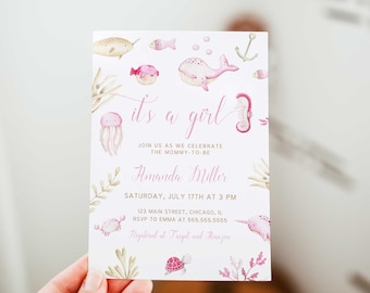 May include: Pink and white baby shower invitation with a watercolor illustration of sea creatures, including a whale, a narwhal, a seahorse, a jellyfish, and a crab. The text reads "it's a girl" and includes the name Amanda Miller, the date and time of the shower, and the address. The invitation also includes the text "Registered at Target and Amazon".