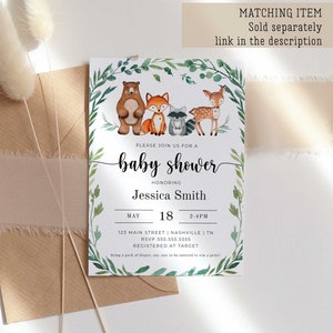 May include: A baby shower invitation with a watercolor illustration of woodland animals, including a bear, fox, raccoon, and deer. The invitation is decorated with green leaves and has the text "Please join us for a baby shower honoring Jessica Smith" and details for the event.