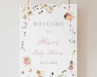Puede incluir: Un cartel de bienvenida blanco con un borde floral y dos hadas. El cartel dice "Bienvenido a la fiesta de bienvenida de Marie Julio, 2022".