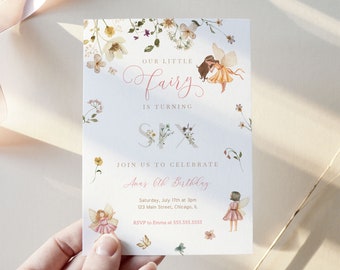 Puede incluir: Una invitación de cumpleaños con temática de hadas. La invitación presenta ilustraciones florales y el texto "Our Little Fairy is Turning Six". La invitación incluye los detalles del cumpleaños: fecha, hora, lugar e información de RSVP.
