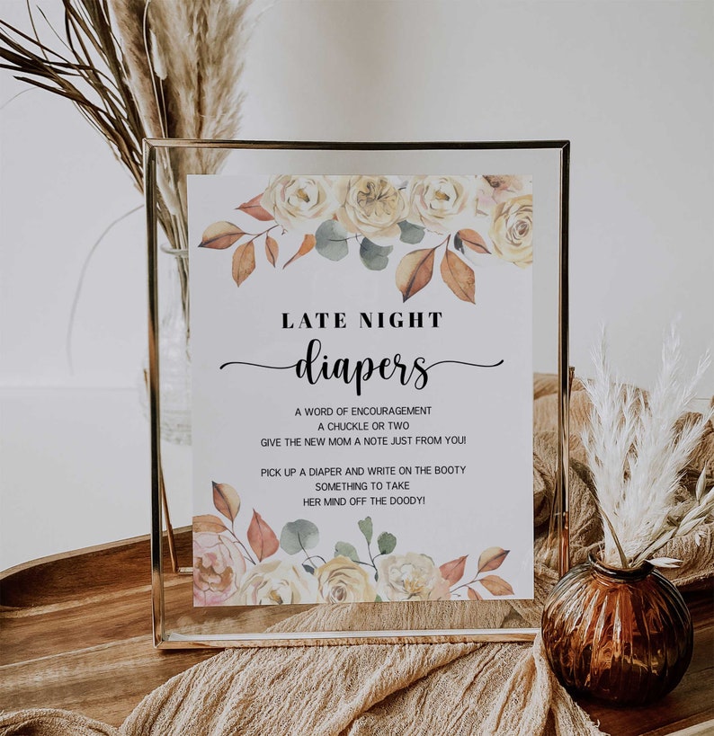 May include: A framed sign with the words "LATE NIGHT diapers" in elegant script. The sign is decorated with watercolor floral elements in shades of yellow, peach, and brown. The text below offers suggestions for diaper changes.