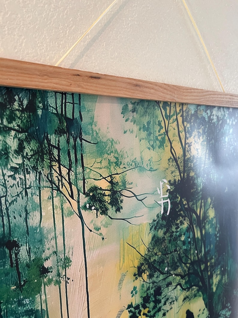 Puede incluir: Una impresi&oacute;n enmarcada de una pintura de acuarela que representa una escena de bosque con tonos verdes y amarillos. La pintura presenta un solo personaje blanco en la esquina inferior derecha.