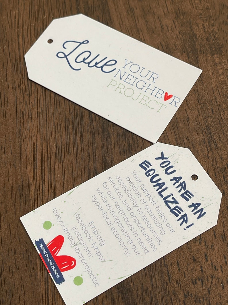 Pu&ograve; includere: Due carte bianche con testo e un cuore rosso. La carta superiore dice "Love Your Neighbor Project" con un cuore rosso. La carta inferiore dice "You Are An Equalizer!" e contiene testo sul supporto alla missione di equalizzare l'accessibilit&agrave; alle risorse, ai servizi e alle opportunit&agrave; per i vicini in difficolt&agrave;. Il testo menziona anche la rivitalizzazione dell'economia iperlocale. La carta include le informazioni di contatto per l'organizzazione.