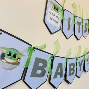 May include: A blue and black banner with green ribbon, featuring a cartoon character and the text "It's a Baby Jedi".