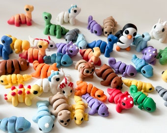 May include: A collection of colorful, hand-painted, segmented animal figurines. The figurines are made of polymer clay and feature a variety of animals, including a penguin, a unicorn, a snake, and a chameleon.