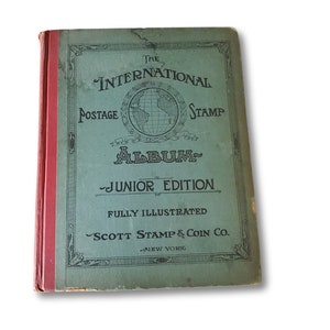 The cover of a green and red book titled "The International Postage Stamp Album - Junior Edition" by Scott Stamp & Coin Co. New York. The book is fully illustrated.