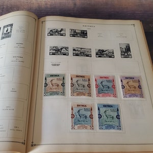 A vintage stamp collection album with pages dedicated to Eritrea. The album features a variety of stamps with different designs, including a stamp with a gazelle and the text "Eritrea" in black and white.