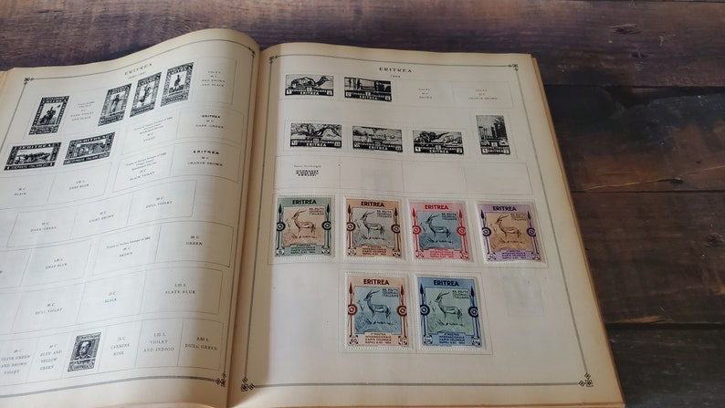 A vintage stamp collection album with pages dedicated to Eritrea. The album features a variety of stamps with different designs, including a stamp with a gazelle and the text "Eritrea" in black and white.