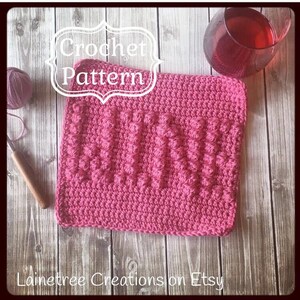 May include: A pink crochet pattern with the word "WINE" in raised letters. The image includes a ball of yarn, a crochet hook, and a glass of red wine. The text "Crochet Pattern" is at the top of the image.