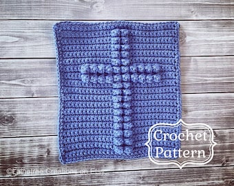 May include: A crochet pattern for a blue cross with a textured design. The pattern is written in white text on a white background.