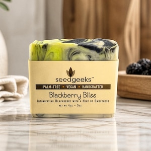 May include: A rectangular bar of soap with a marbled black and lime green pattern, wrapped in a beige paper label. The label reads seedgeeks, Blackberry Bliss, Intoxicating Blackberry with a Hint of Sweetness, and Net Wt 4oz - 5oz.