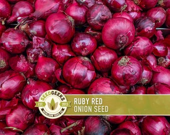 May include: A close-up of a pile of ruby red onions. The onions are a deep red colour with a slightly textured surface. The image includes a logo that says "SEED GEEKS" and the text "RUBY RED ONION SEED".