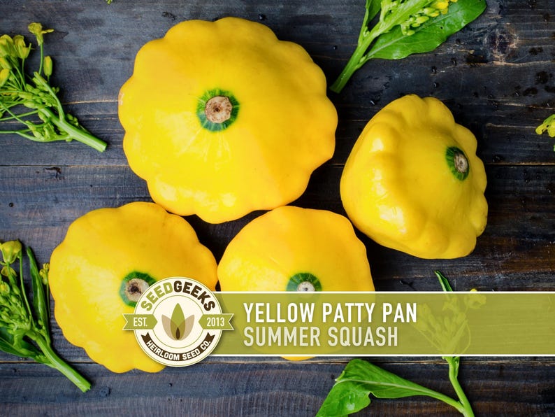 a collection of yellow squash on a wooden surface, with some leaves and flowers scattered around them.