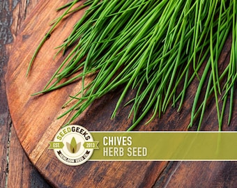 Könnte beinhalten: Frische grüne Schnittlauch auf einem Holzschneidebrett. Das Bild enthält ein Logo mit der Aufschrift "Seed Geeks" und den Text "Chives Herb Seed". Der Schnittlauch ist leuchtend grün und scheint frisch geerntet zu sein.