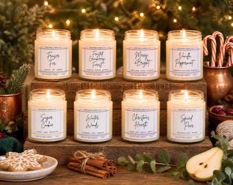May include: Eight glass jar candles with white wax and lit wicks, arranged on a wooden stand. Each candle features a label with the text: Fraser Fir, Frosted Cranberry Forest, Merry & Bright, Vanilla Peppermint, Sugar Cookie, Winter Woods, Christmas Hearth, and Spiced Pear.