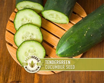 May include: Freshly sliced cucumbers on a wooden surface. The image features whole cucumbers and several green cucumber slices, showcasing the vegetable's texture and color. The text on the image reads "Tendergreen Cucumber Seed".