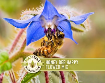 May include: A close-up of a bee pollinating a vibrant blue flower. The flower has delicate petals and is surrounded by green foliage. The image includes the text "HONEY BEE HAPPY FLOWER MIX" and the Seed Geeks logo.
