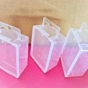 May include: Three clear plastic boxes with handles. The boxes are empty and have a rectangular shape.