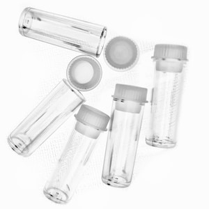 May include: A set of six clear glass vials with white plastic caps. The vials are empty and are arranged in a random pattern on a white background.