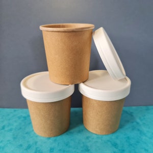 May include: Three brown paper cups with white lids. The cups are stacked on top of each other.
