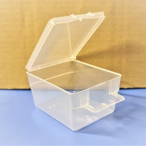 May include: A clear plastic storage box with a hinged lid and a small handle on the side.