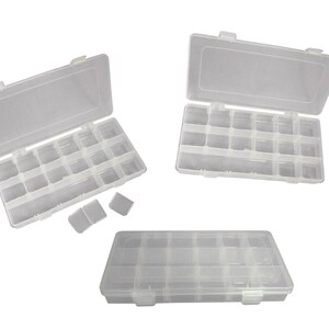 May include: Three clear plastic storage boxes with multiple compartments. The boxes have hinged lids and secure catches. The compartments are designed to hold small items, such as beads, jewellery, or craft supplies. The boxes are shown open and closed.