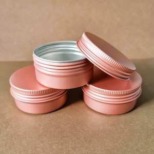 May include: Four rose gold metal tins with lids. The tins are stacked on top of each other.
