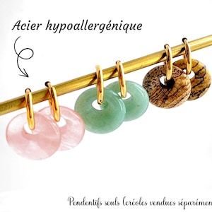Puede incluir: Cuatro pares de pendientes de aro de oro hipoalergénicos con dijes de piedra de diferentes colores. Los dijes son de color rosa, verde y marrón.