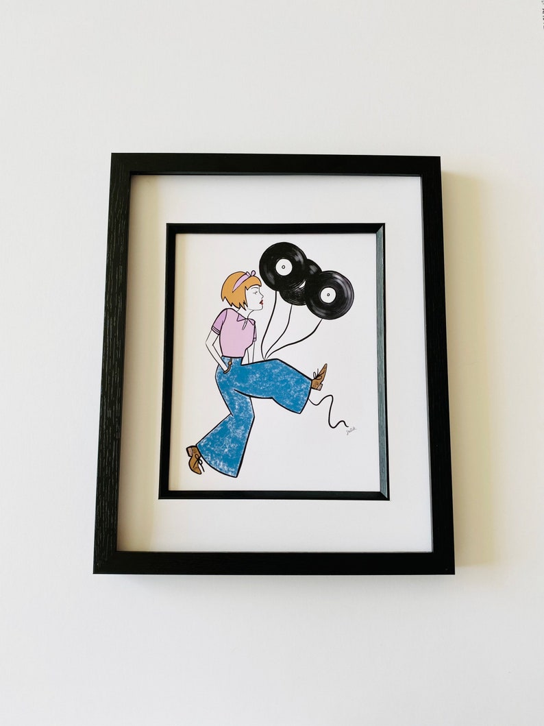 May include: A framed illustration of a woman wearing blue jeans and a pink shirt, holding three black vinyl records as balloons.