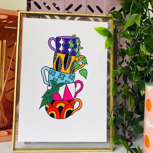 May include: A stack of four colorful mugs with geometric and floral patterns. The mugs are stacked on top of each other and a green plant is growing out of the top mug.