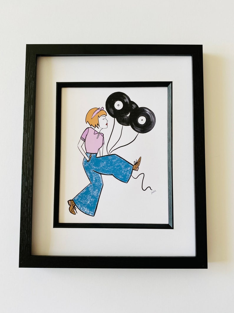 May include: A framed illustration of a person wearing blue jeans and a pink shirt, holding two black vinyl records as balloons. The person is walking and smiling.
