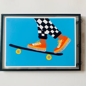 Pu&ograve; includere: Una gamba di pantalone a stampa a scacchi bianco e nero e scarpe da ginnastica arancioni e gialle su uno skateboard con ruote gialle su uno sfondo blu.