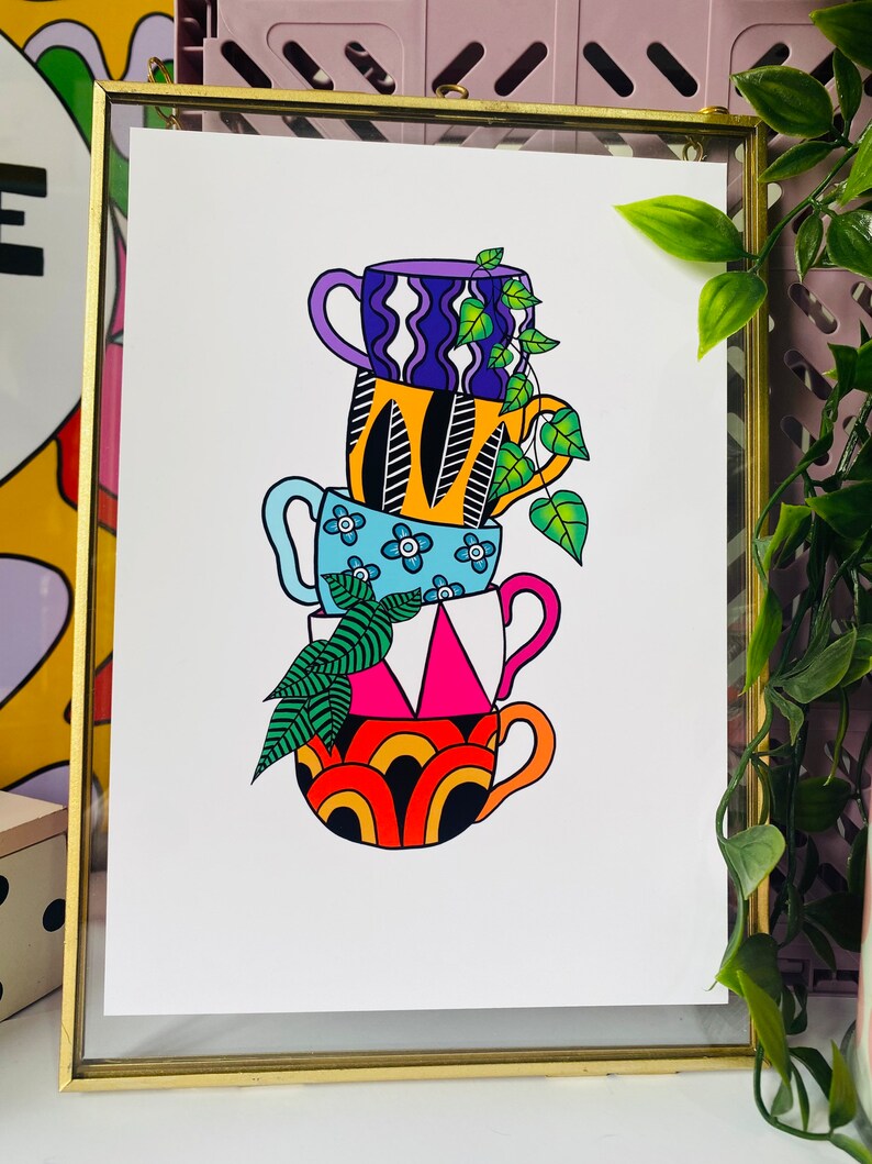 May include: A stack of four colorful mugs with different patterns, including a blue mug with white flowers, a pink and white mug with a geometric design, an orange and black mug with a wavy pattern, and a purple and white mug with a wavy pattern. A green plant with leaves is growing out of the top mug.