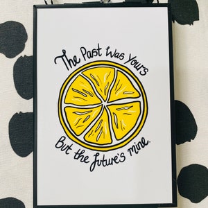 K&ouml;nnte beinhalten: Ein gerahmter Druck mit einer gelben Zitronenscheibe und dem Text "The past was yours but the future's mine."