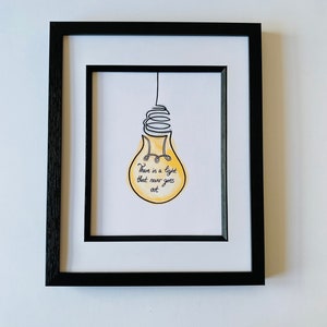 May include: A framed print with a yellow lightbulb illustration and the text "There is a light that never goes out."