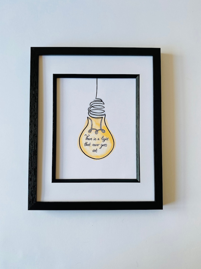 May include: A framed print with a yellow lightbulb illustration and the text "There is a light that never goes out."