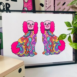May include: A framed print of two colorful, psychedelic dogs with pink fur and a swirl pattern. The dogs are facing forward and have black collars with silver chains.