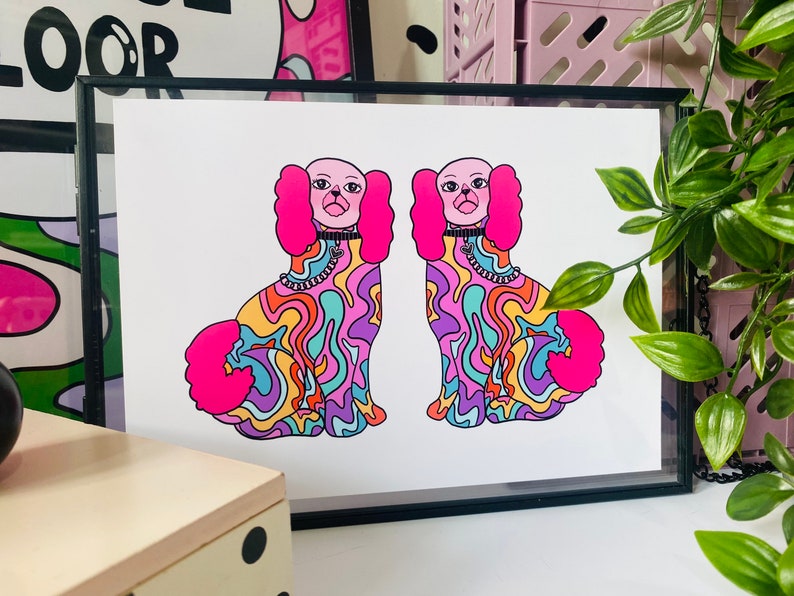 May include: A framed print of two colorful, psychedelic dogs with pink fur and a swirl pattern. The dogs are facing forward and have black collars with silver chains.