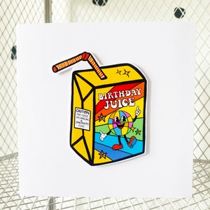 May include: A yellow and red birthday juice box with a cartoon character on the front. The character is a smiling, rainbow-colored globe with legs and arms. The text on the box reads "Birthday Juice" and "Caution: May cause joy, dancing, and spontaneous fun."