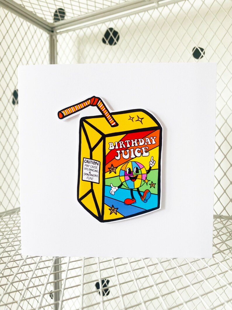 May include: A yellow and red birthday juice box with a cartoon character on the front. The character is a smiling, rainbow-colored globe with legs and arms. The text on the box reads "Birthday Juice" and "Caution: May cause joy, dancing, and spontaneous fun."