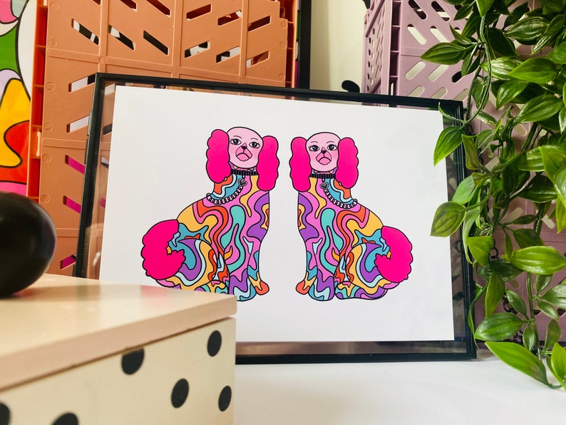 May include: A framed print of two psychedelic dogs with pink fur, colorful swirls, and black collars. The dogs are facing each other and have a similar design.