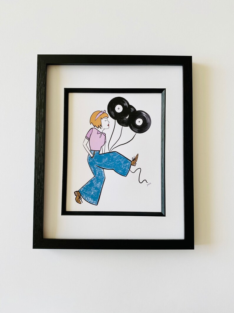 May include: A framed illustration of a woman wearing blue jeans and a pink shirt, holding three black vinyl records as balloons.