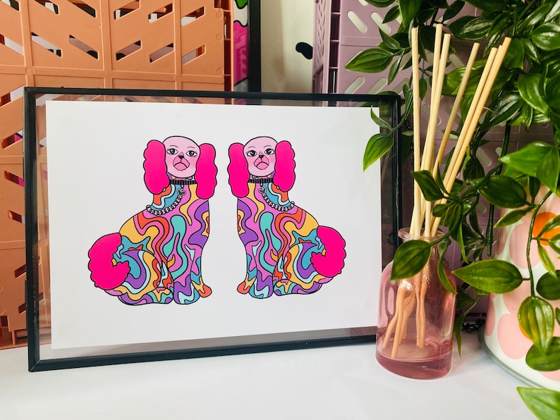 May include: A framed print of two colorful, psychedelic dogs with pink fur and swirling patterns. The dogs are facing forward and have black eyes and pink noses.