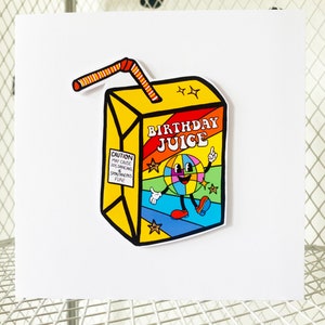 May include: A yellow juice box with a red and orange striped straw. The juice box has a cartoon character on it with a rainbow colored globe for a head and the words "Birthday Juice" on the front. The juice box has a warning label that says "Caution: May cause joy, dancing, & spontaneous fun!"