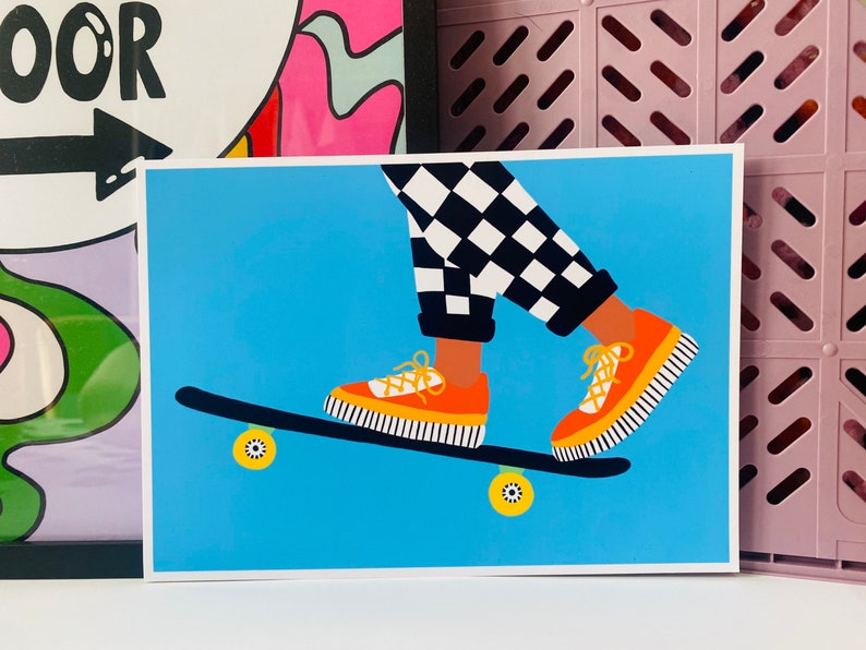 Pu&ograve; includere: Una persona con pantaloni a scacchi bianchi e neri sta facendo skateboard. Indossa scarpe arancioni con strisce nere. Lo skateboard &egrave; nero con ruote gialle.